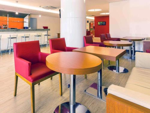 - une salle d'attente avec des tables et des chaises rouges dans l'établissement Ibis Mossoro, à Mossoró