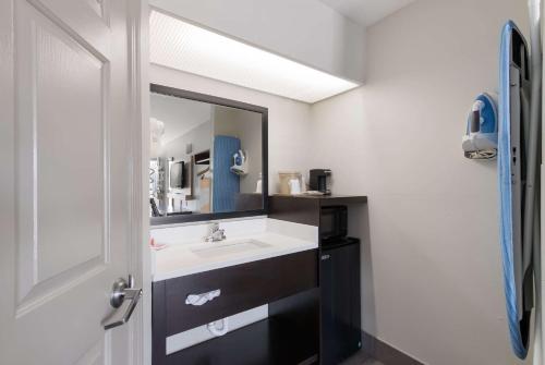une salle de bain avec un lavabo et un miroir dans l'établissement Econo Lodge, à Greenville