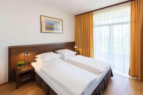 a large bed in a room with a large window at VacationClub - Diune Apartment 64 in Kołobrzeg