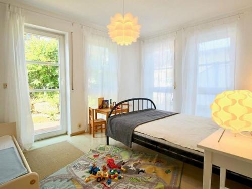 1 dormitorio con cama, mesa y ventanas en Komfort-Ferienwohnung am See en Bodman-Ludwigshafen