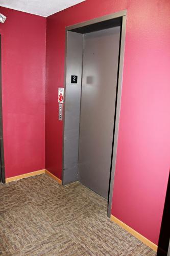 a elevator door in a room with red walls at Capri Inn & Suites - Beatrice in Beatrice