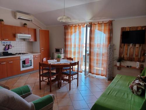 a kitchen and living room with a table and chairs at Apartments Ivić in Rab