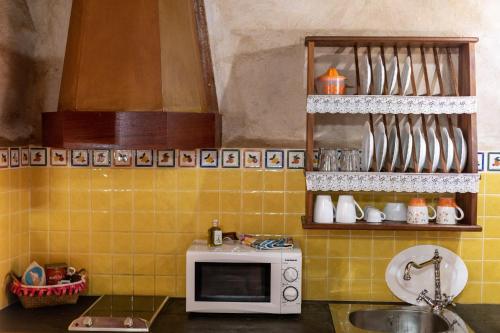 a kitchen with a microwave and a sink in it at Casa Rural Tamasite in Tuineje