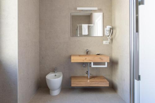 Un baño con inodoro, lavabo y espejo. en Luciano Licia Guest House, en Roma