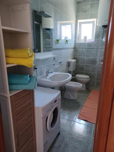 a bathroom with a washing machine and a sink at Apartments Ivić in Rab