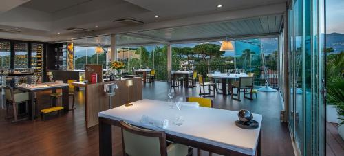 a restaurant with tables and chairs and a balcony at Principe Forte Dei Marmi - Resort & Spa in Forte dei Marmi