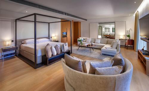 a bedroom with a bed and a living room at Hotel Principe Forte Dei Marmi in Forte dei Marmi