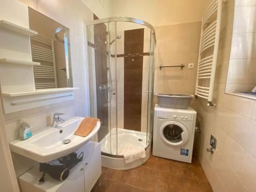 a bathroom with a sink and a washing machine at ORANGEHOMES One Bedroom Cozy Apartment in Budapest