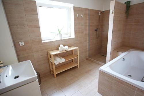 a bathroom with a tub and a shower and a sink at Husovka No135 in Libice nad Cidlinou