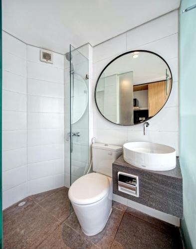 a bathroom with a toilet and a sink and a mirror at Sakura Terrace Benhil in Jakarta