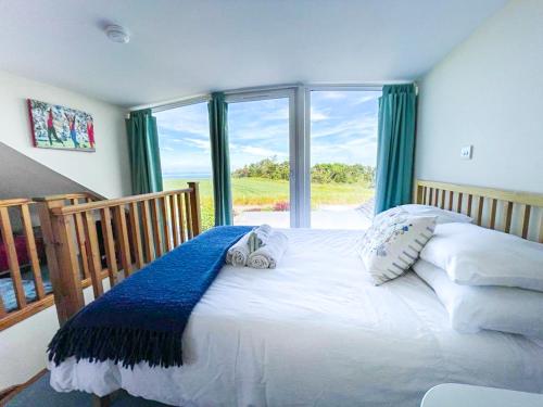 Schlafzimmer mit einem Bett und einem großen Fenster in der Unterkunft Quirky, Cosy 3BR Cottage With Patio in Canty Bay, Sleeps 10 in North Berwick