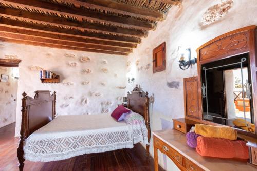 1 dormitorio con cama y espejo en una habitación en Casa Rural Tamasite, en Tuineje