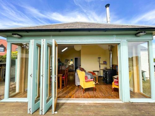 a conservatory with sliding glass doors on a deck at Quirky, Cosy 3BR Cottage With Patio in Canty Bay, Sleeps 10 in North Berwick