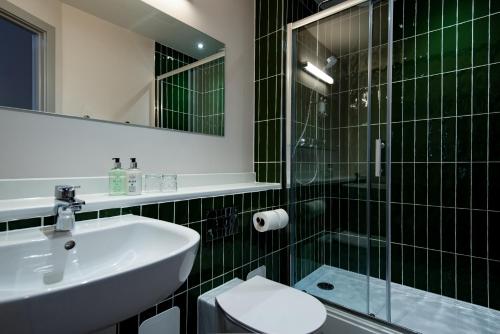 a bathroom with a sink and a glass shower at The Northallerton Inn - The Inn Collection Group in Northallerton