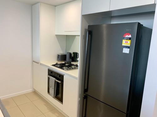a kitchen with a stainless steel refrigerator and a stove at Serenity Harbour Views at Darwin Waterfront in Darwin