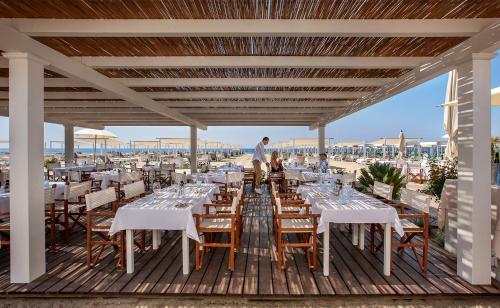 a dining area with tables and chairs on a deck at Principe Forte Dei Marmi - Resort & Spa in Forte dei Marmi