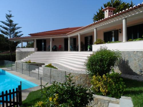 a villa with a swimming pool and a house at Hedone Sintra in Sintra
