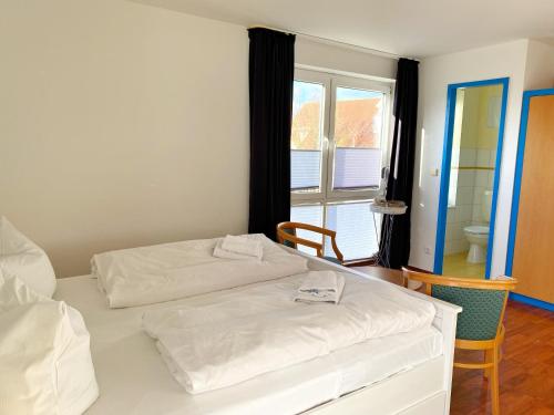 2 camas en una habitación con ventana y una habitación en Hafenresidenz - Ferienwohnung 31, en Wiek auf Rügen