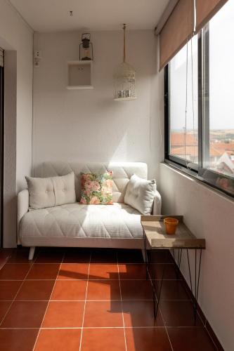 a living room with a white couch and a window at Bragança Apartments in Bragança
