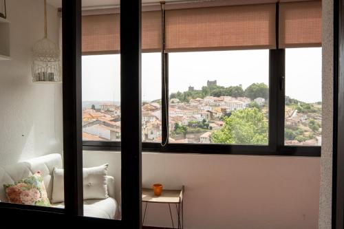 a living room with a window view of a city at Bragança Apartments in Bragança