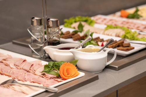 a buffet with several plates of food on a table at Hotel Nowy Zdrój - Centrum Zdrowia i Wypoczynku in Polanica-Zdrój