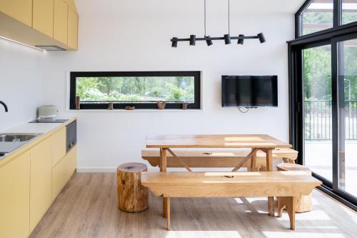 a kitchen and dining room with a table and benches at Montesinho Eco-Resort in Bragança