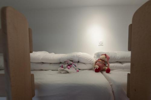 two stuffed teddy bears sitting on top of a couch at Les Clés de La porte Saint-Nicolas - Parking - Centre in Beaune