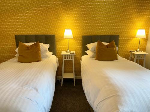 two beds in a room with two lamps on tables at Barriemore Oban in Oban