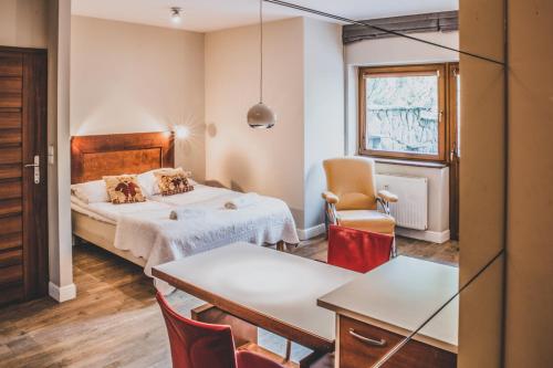 pokój hotelowy z łóżkiem, stołem i krzesłami w obiekcie TatryTop Pod Skocznią w Zakopanem