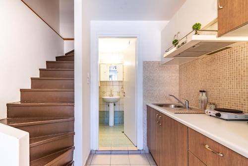 a kitchen with a sink and a stairway at Cozy Loft near Downtown in Heraklio