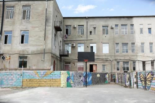 an old building with a fence in front of it at Hostel Mandaria in Kutaisi