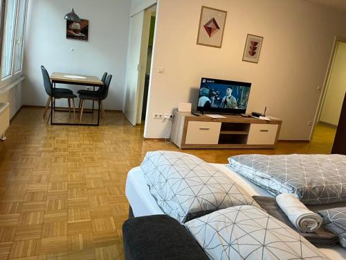a living room with a couch and a tv and a table at House Marin II - Apartment in Maribor