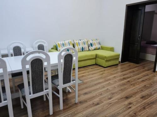sala de estar con mesa, sillas y sofá en Apartament La Cetate, en Aiud