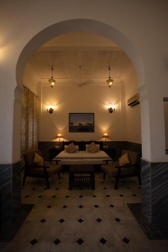 a hotel room with a bed and two chairs at Diggi Palace - A City Center Hidden Heritage Gem in Jaipur
