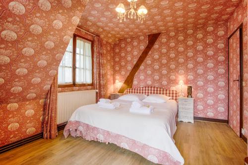 a bedroom with a large bed in a room with wallpaper at Luxueuse Chaumière 4 Chambres avec jardin in Deauville