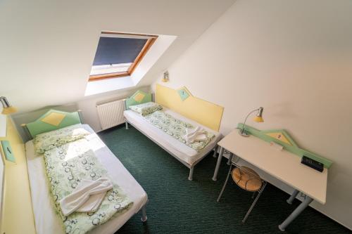 a small room with two beds and a desk at MP Hostel Budapest in Budapest