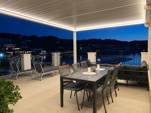 a dining table and chairs on a patio at Apartments Barbaresko in Lumbarda
