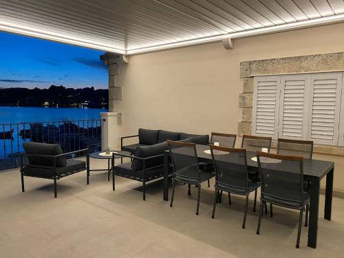 a patio with a table and chairs and a view of the water at Apartments Barbaresko in Lumbarda