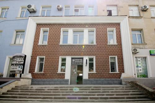 a brick building with stairs in front of it at Hostel Mandaria in Kutaisi