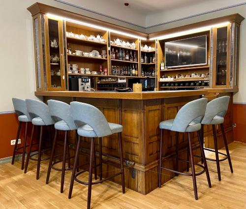 eine Bar mit vier Hockern vor einer Theke in der Unterkunft Lielbornes Muiža Boutique Hotel&Recreation Complex in Lielborna