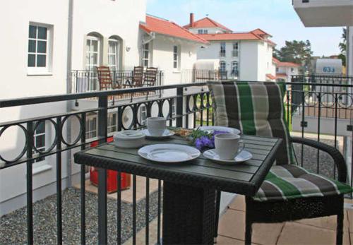 einen Tisch mit zwei Tassen und einem Stuhl auf dem Balkon in der Unterkunft Haus Meeresblick - Ferienwohnung Strandidyll A 1.16 (Ref. 128659 u2) in Baabe