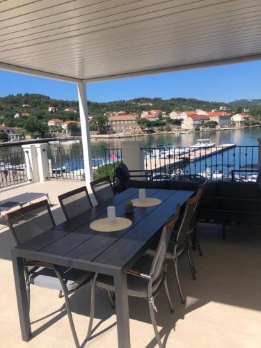 a blue table and chairs with a view of the water at Apartments Barbaresko in Lumbarda