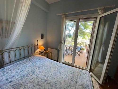 1 dormitorio con cama y ventana grande en Stunning Evia Sea View Country House, en Roïdhítsa