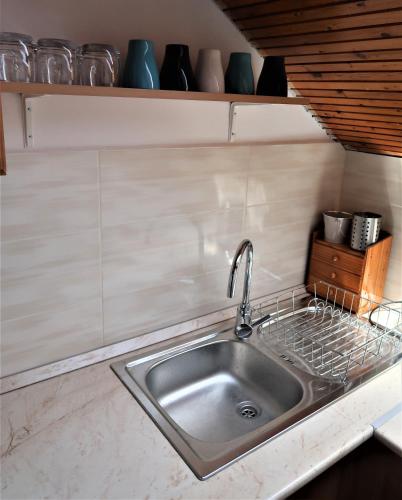 a kitchen sink with a faucet on a counter at Váralja Vendégház Tihany in Tihany