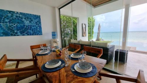 a dining room with a wooden table and a view of the ocean at Laemsor Residence in Laem Sor