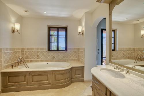 a large bathroom with two sinks and a tub at Domaine des Chênes de la Galline in La Garde-Freinet
