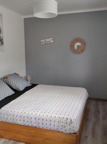 een slaapkamer met een bed en een klok aan de muur bij chambre triple in Ploubazlanec