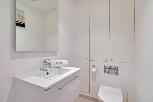 a white bathroom with a sink and a toilet at Andiamo Apartment in Vilamoura