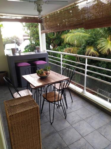 patio con mesa y sillas en el balcón en Le Saint B Leu 3 nuits minimum, en Saint-Leu