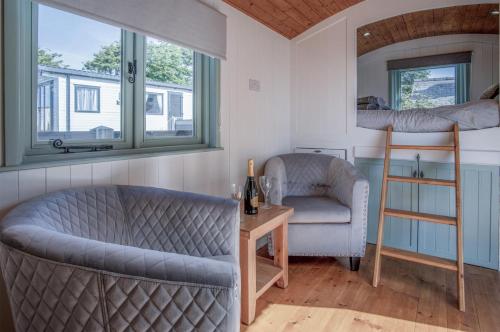 een woonkamer met een bank, een stoel en een stapelbed bij Willow - 1 Bedroom Shepherds Hut - Amroth in Amroth